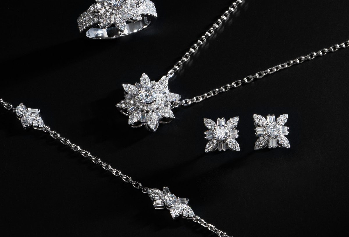 Silver jewellery set laid out on a dark background